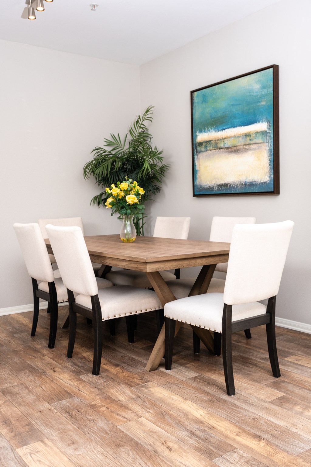 a dining room with a wooden table and white chairs