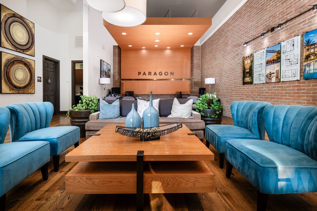 a living room with blue chairs and a wooden table