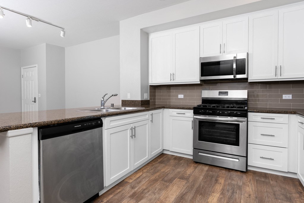 a kitchen with white cabinets and stainless steel appliances