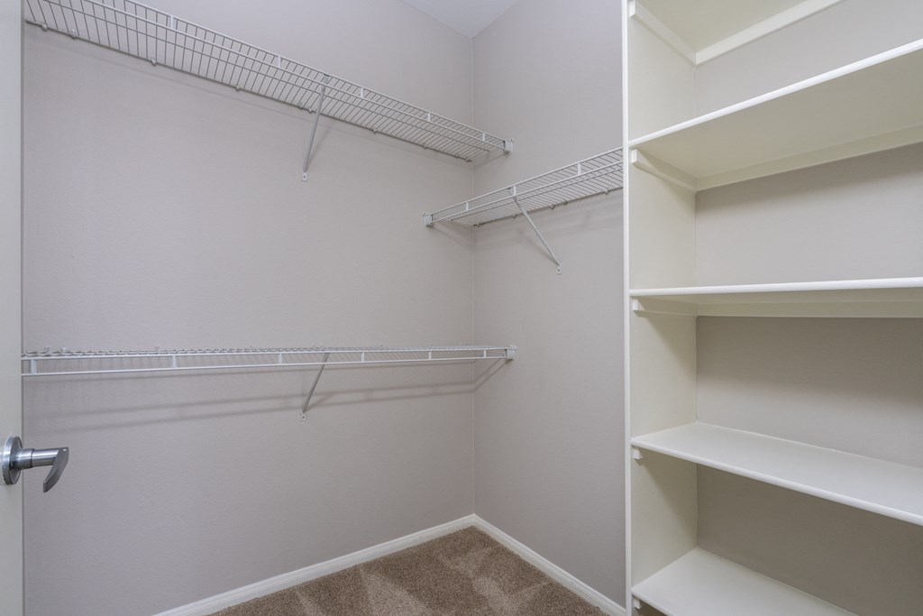 an empty closet with shelves and a door
