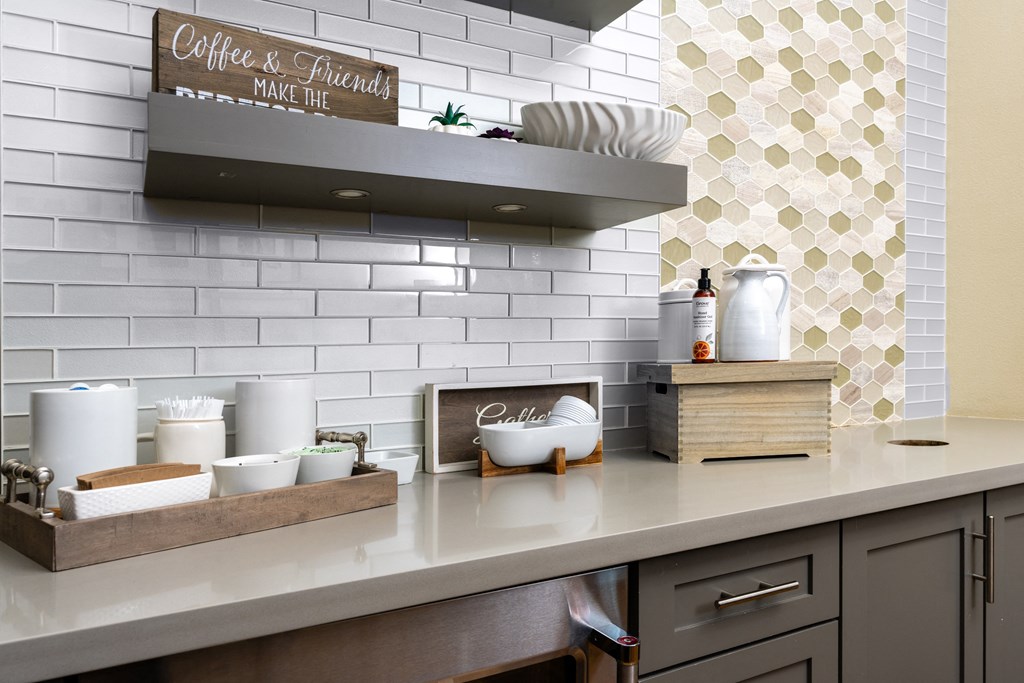 a kitchen counter with a sink and a shelf above it