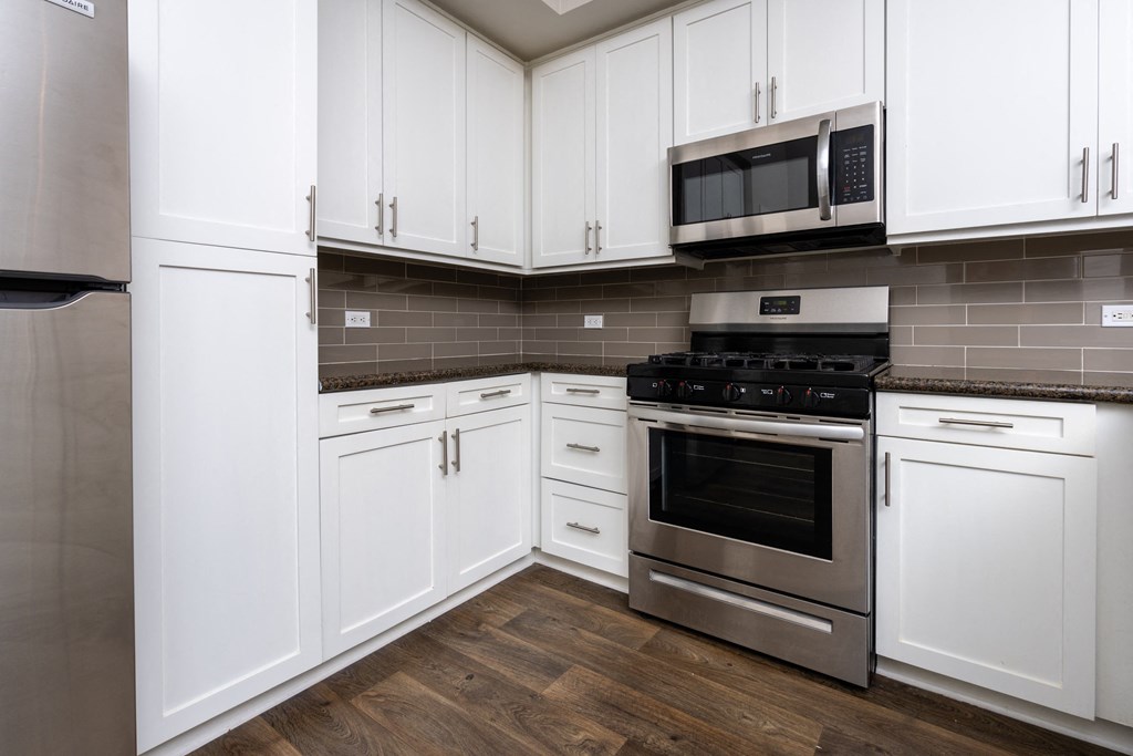 a kitchen with white cabinets and stainless steel appliances