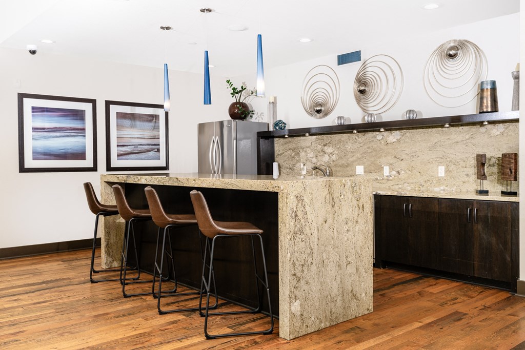a kitchen with a marble counter top and three stools