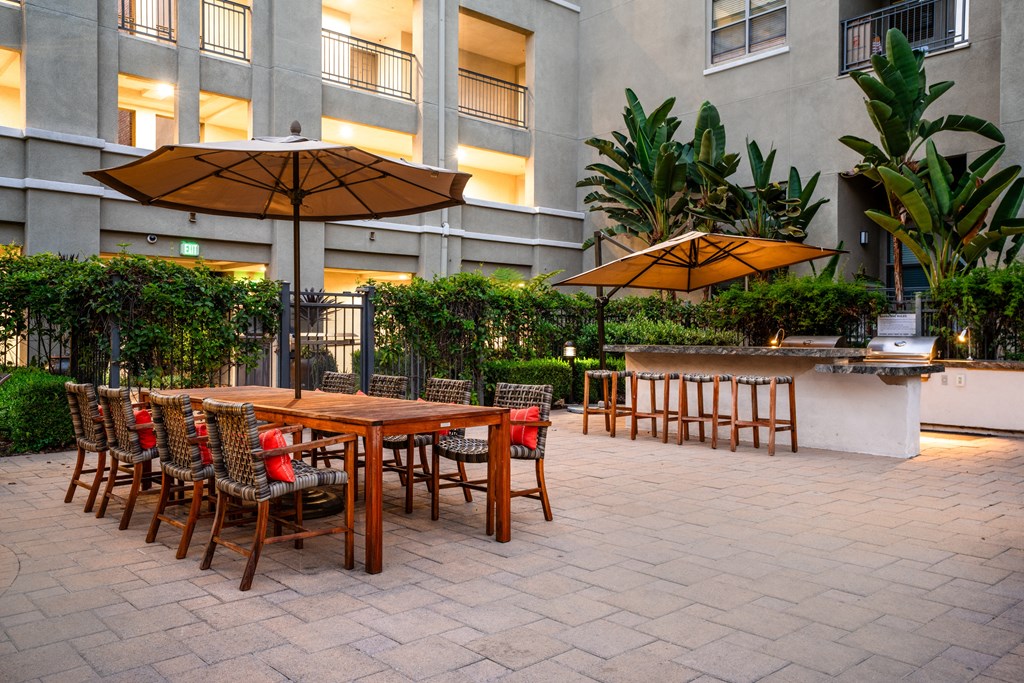 a patio with a table and chairs and umbrellas