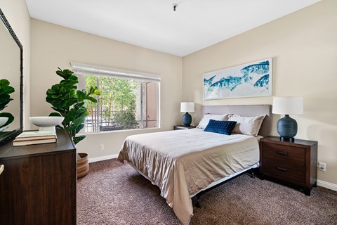 A bedroom with a large bed and a painting on the wall.