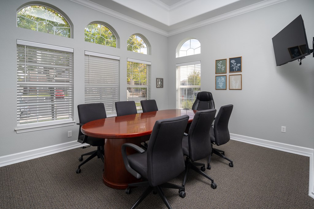 A conference room with a large table and chairs.