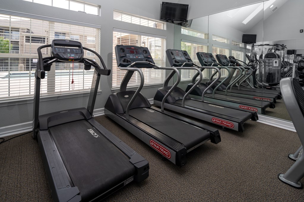 A gym with treadmills and elliptical machines.