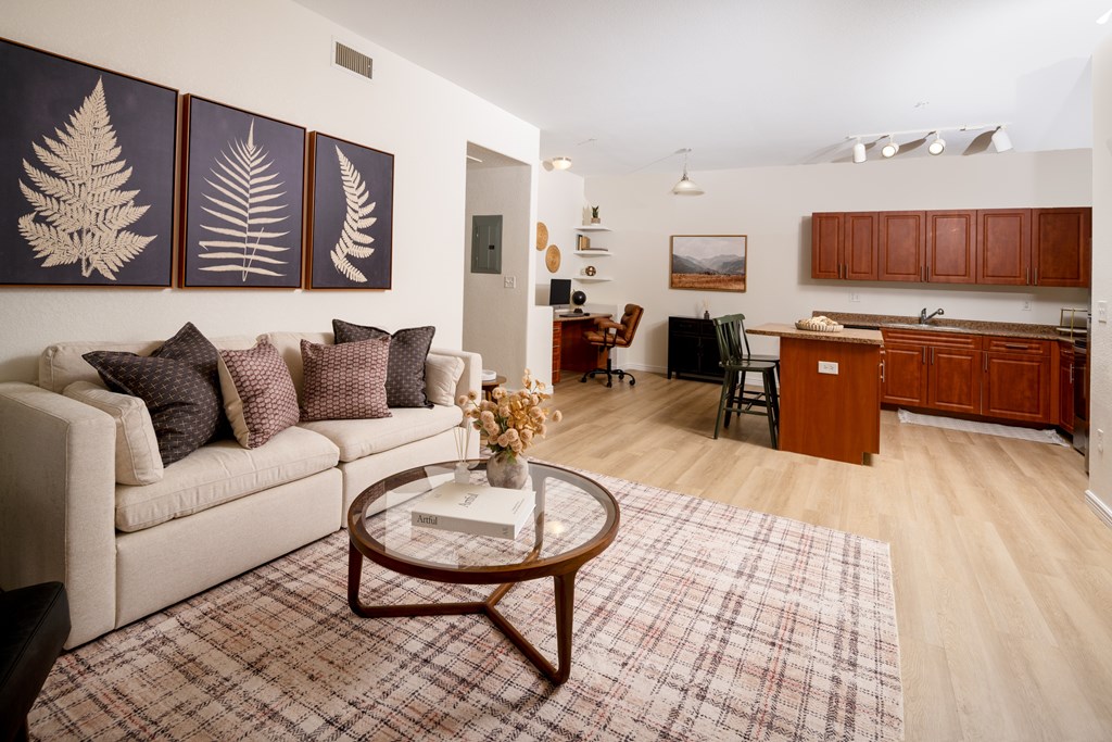 A living room with a couch, coffee table, and pictures on the wall.