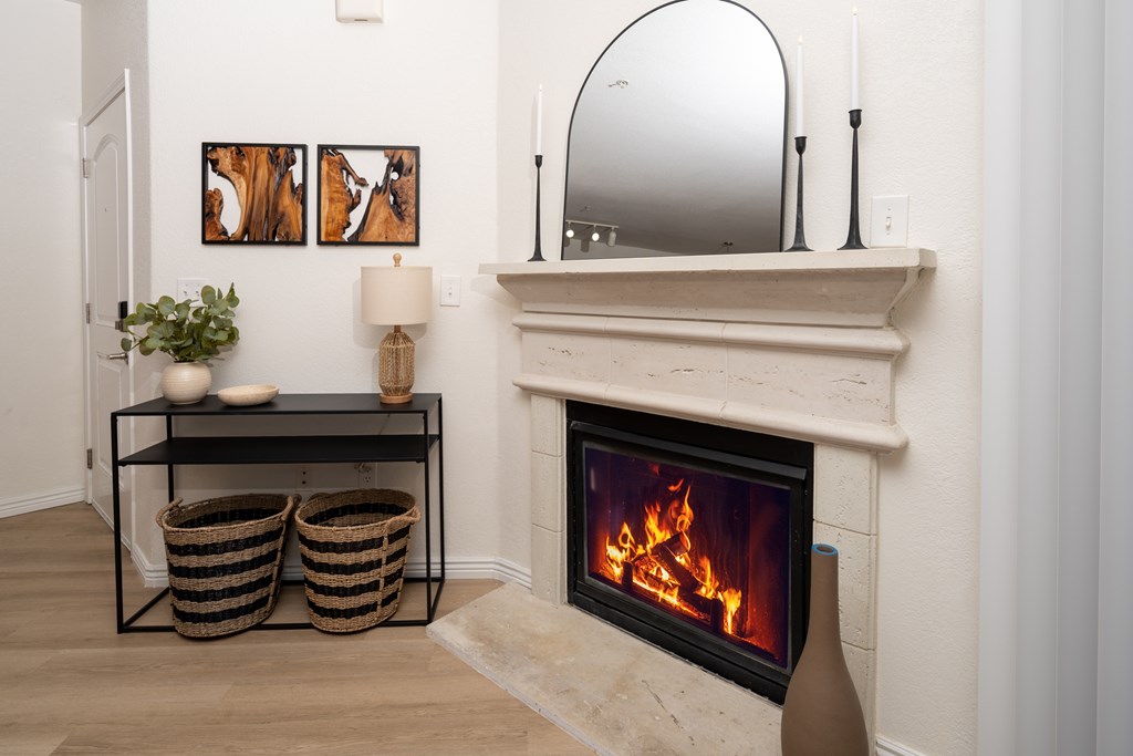 A fireplace with a mirror above it and two baskets on the floor.