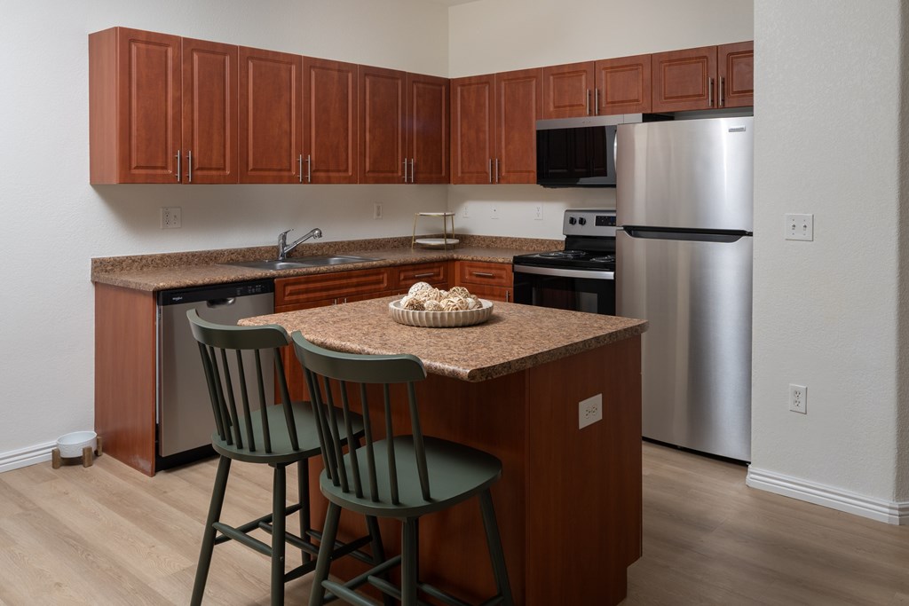 A kitchen with a table and two chairs.
