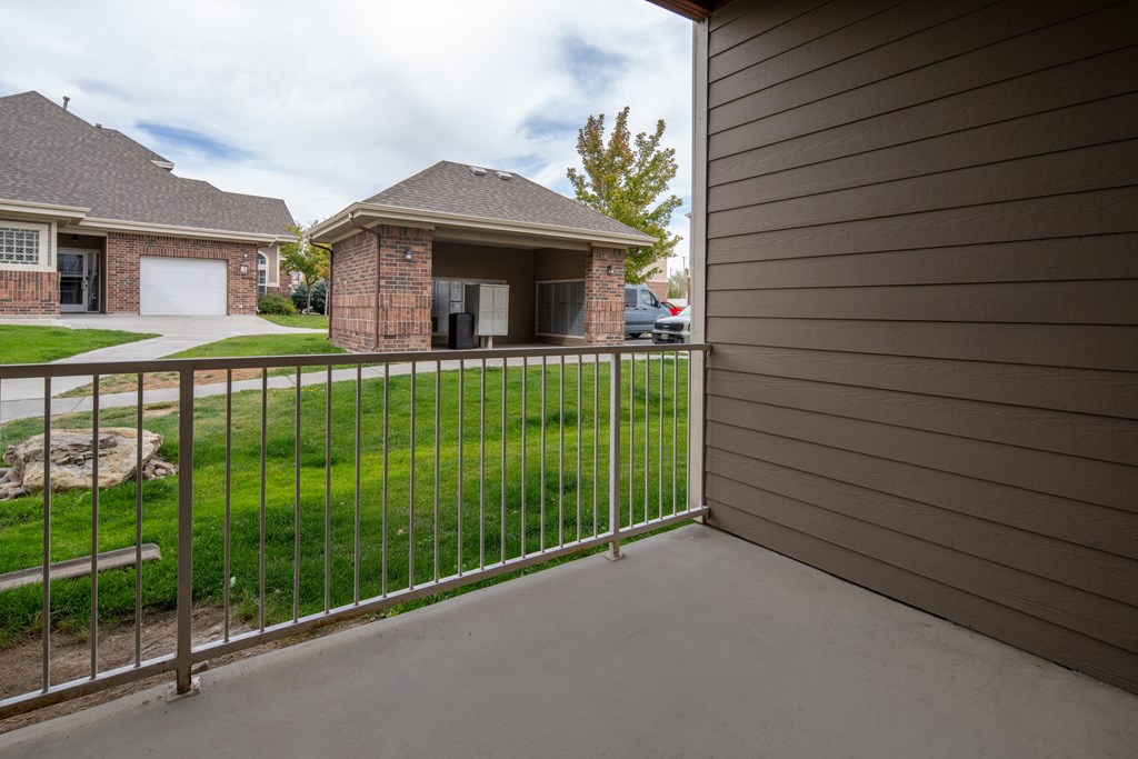 A house with a grey fence and a green lawn.