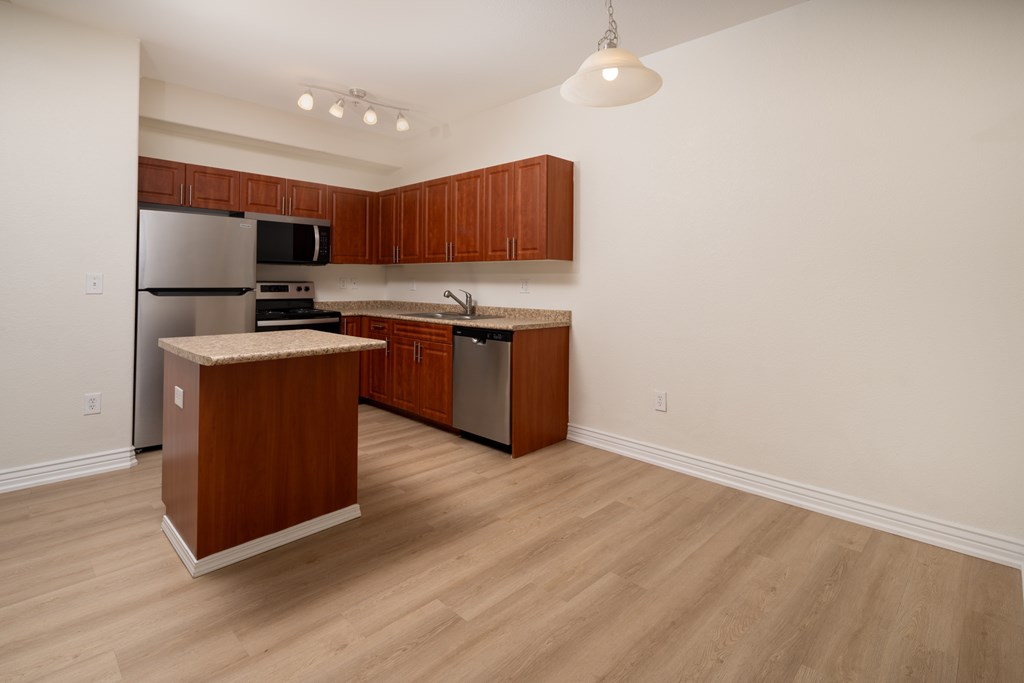 A kitchen with wooden cabinets and a wooden island.