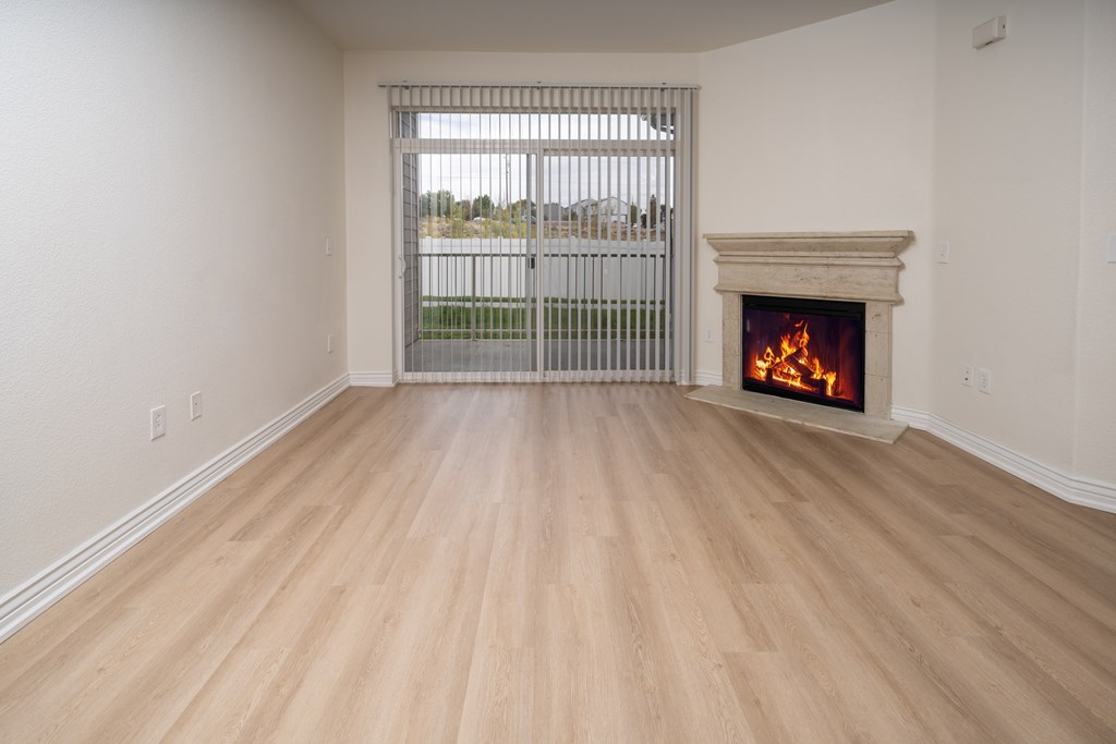 A room with a fireplace and a window with bars.