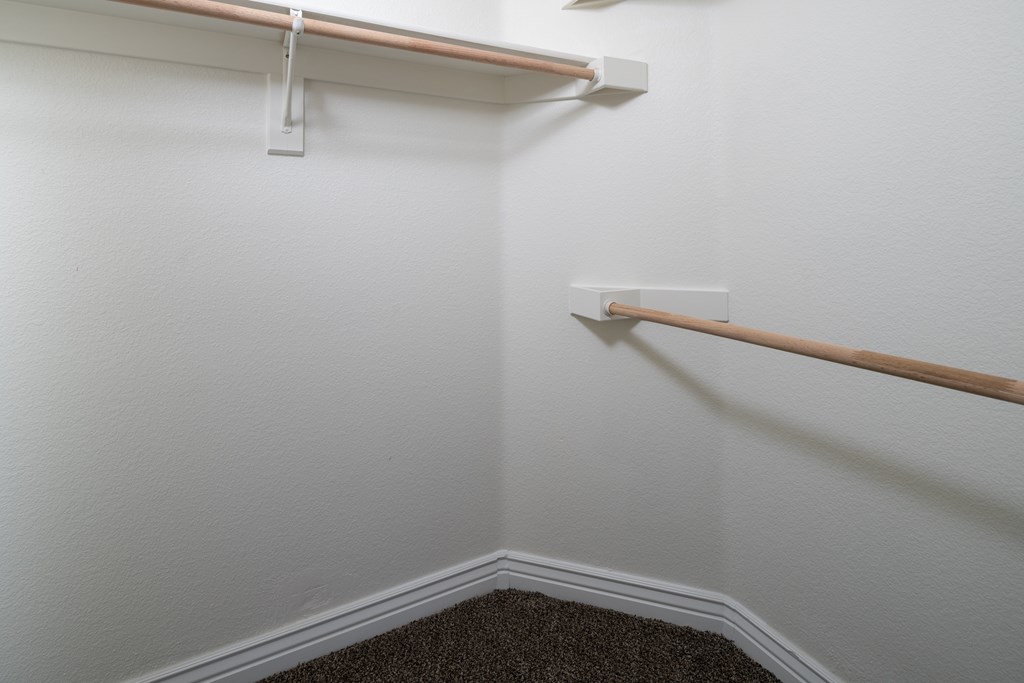 A white wall with a brown trim and a white shelf.