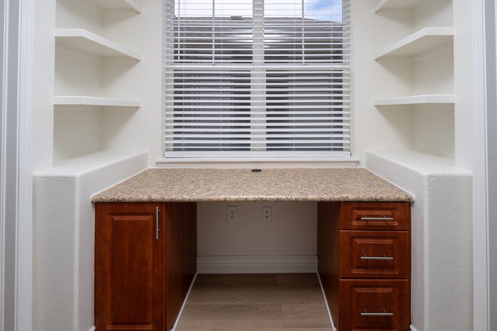 A small home office with a desk and drawers.