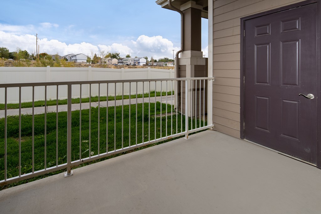 A balcony with a purple door and a metal railing.