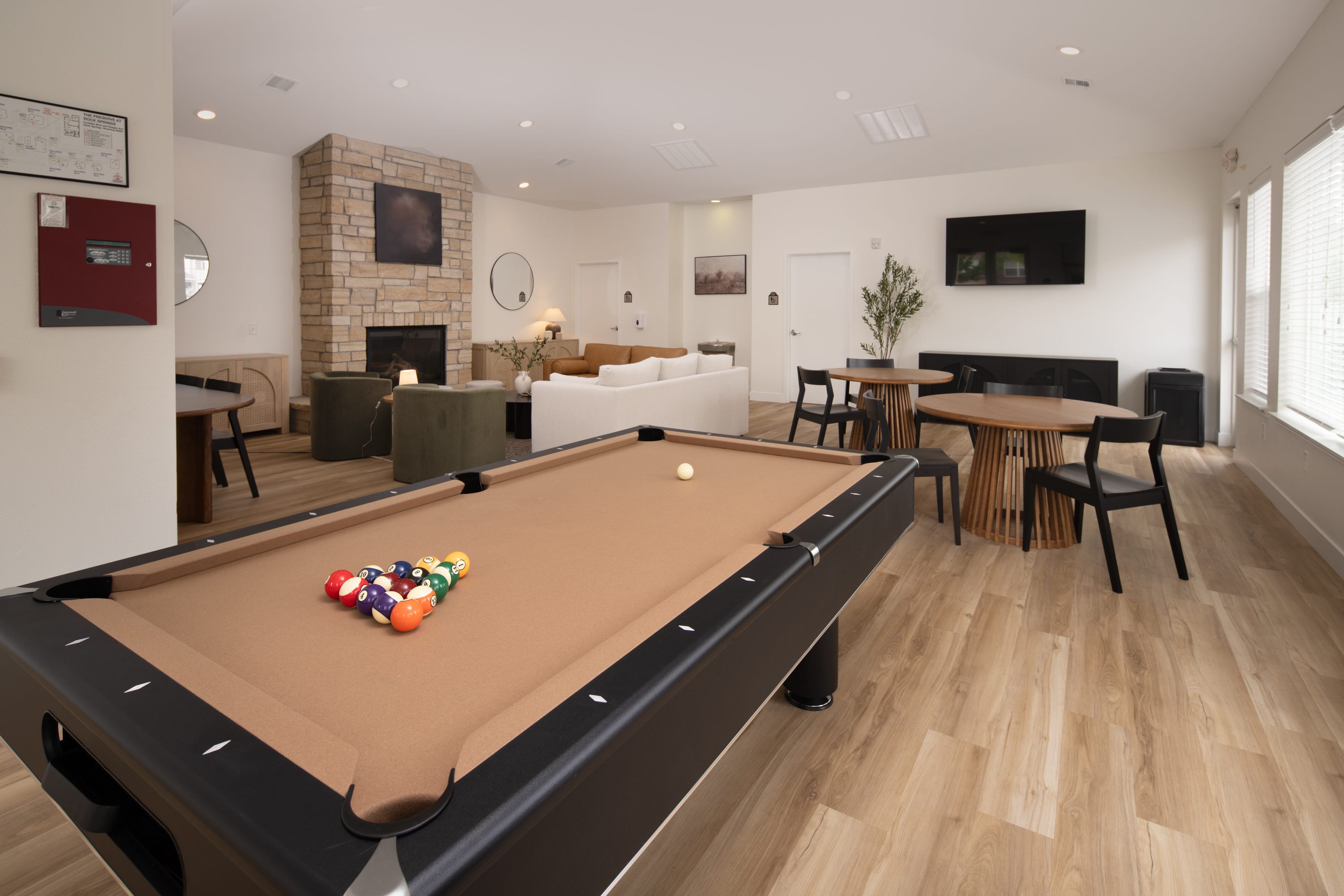 A pool table is in the middle of a living room.