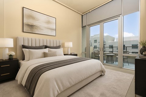 A bedroom with a large bed and a painting on the wall.