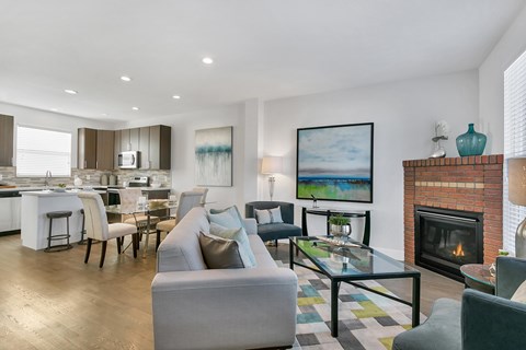 A modern living room with a fireplace and a painting on the wall.
