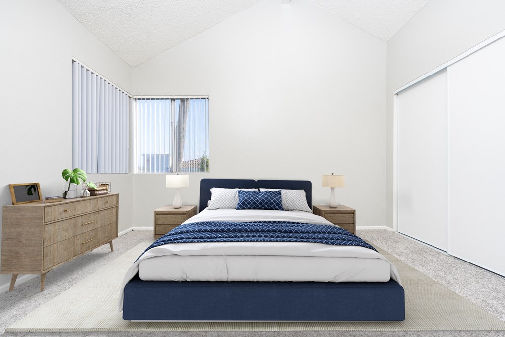 A bedroom with a bed, nightstand, and window with blinds.