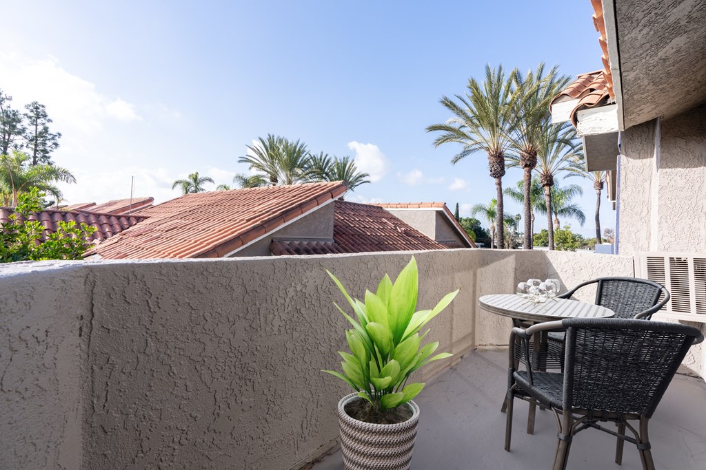 A patio with a table and chairs overlooking a garden.