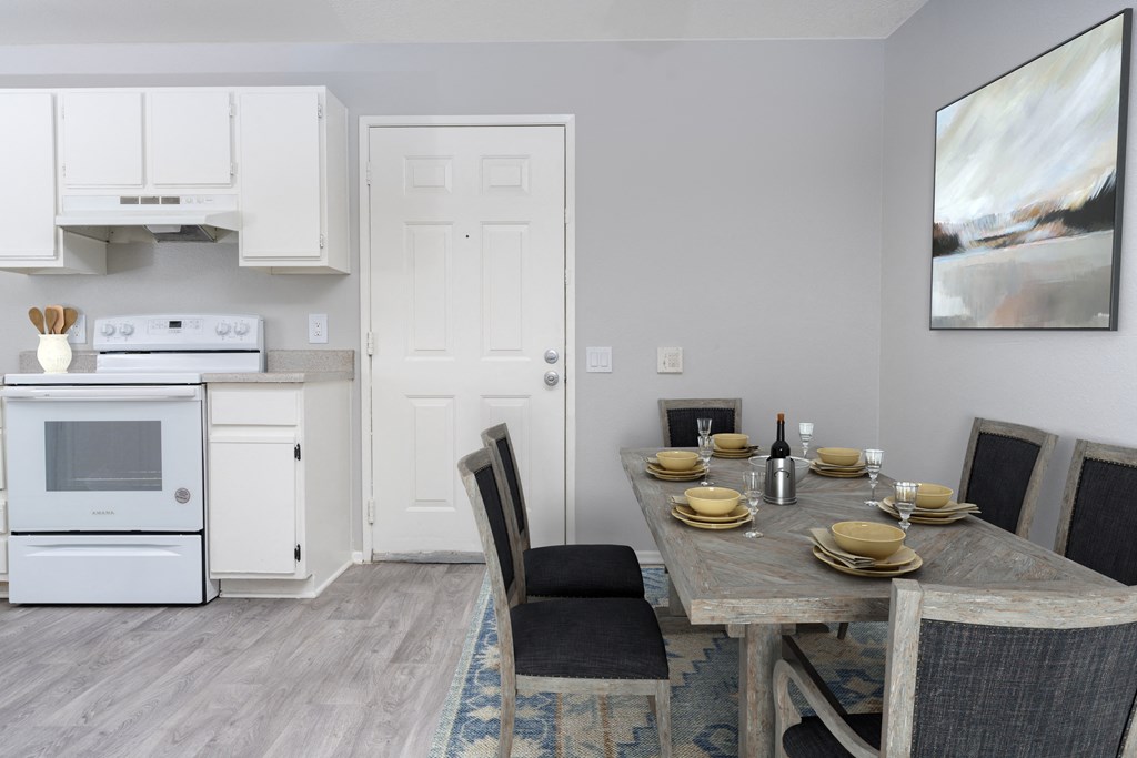 A modern kitchen with a dining table set for two.