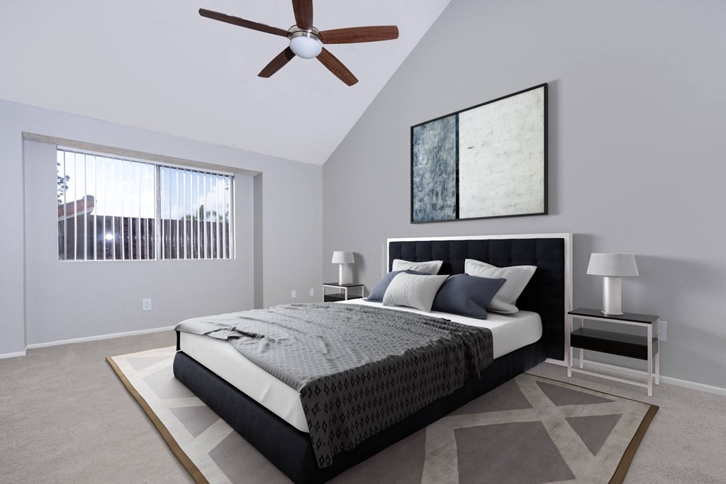 A bedroom with a large bed and a ceiling fan.