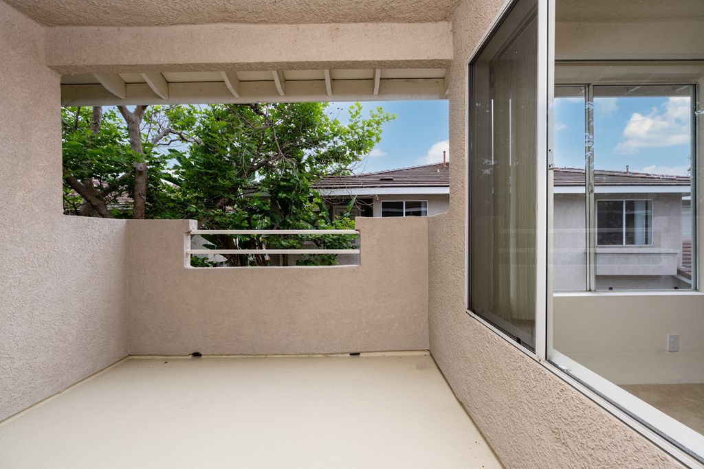 a balcony with a view of a tree and a window