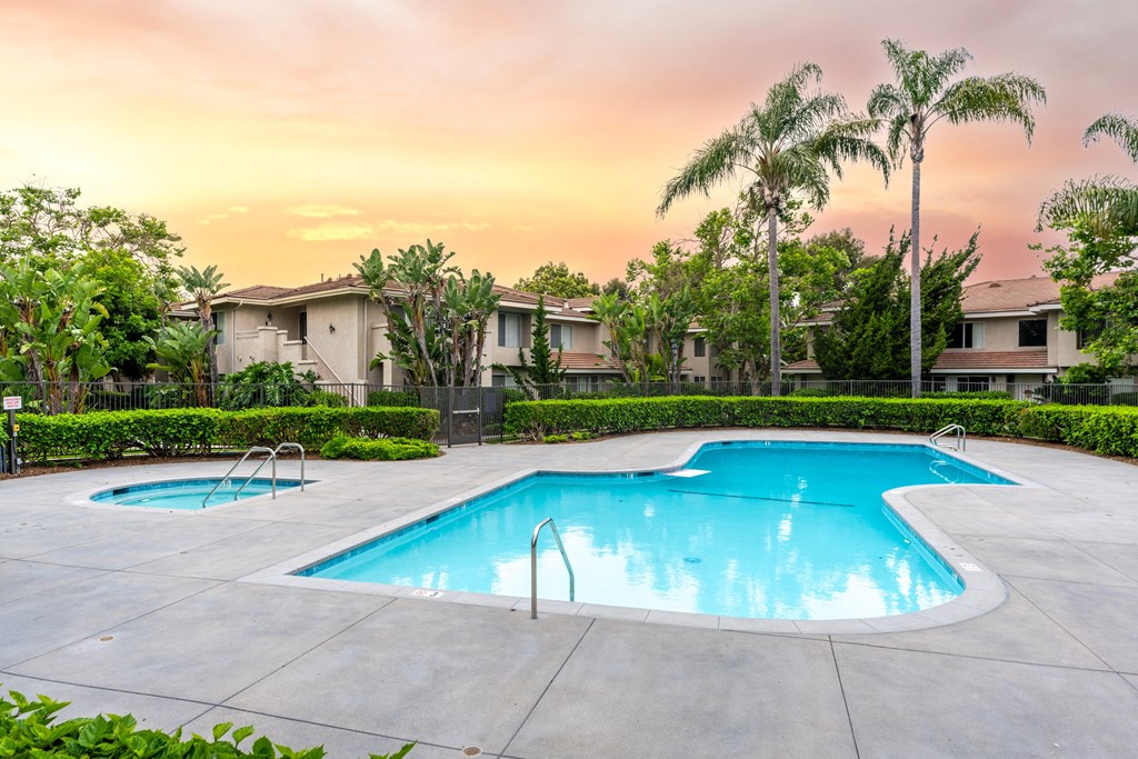 a swimming pool with palm trees and buildings in the background
