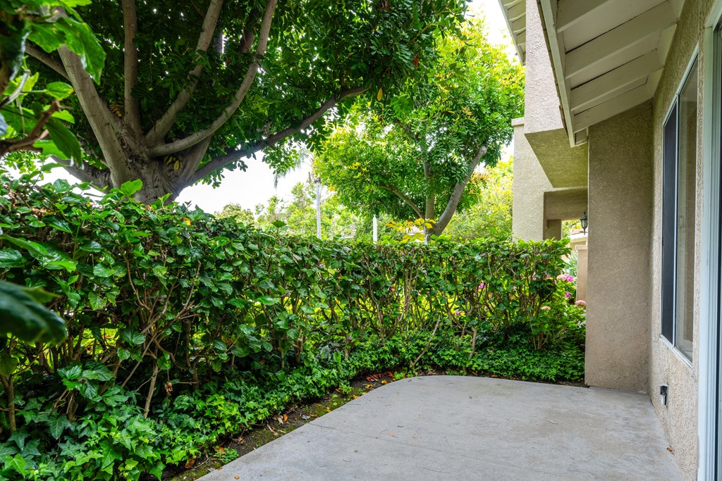 a walkway in front of a building with bushes and trees