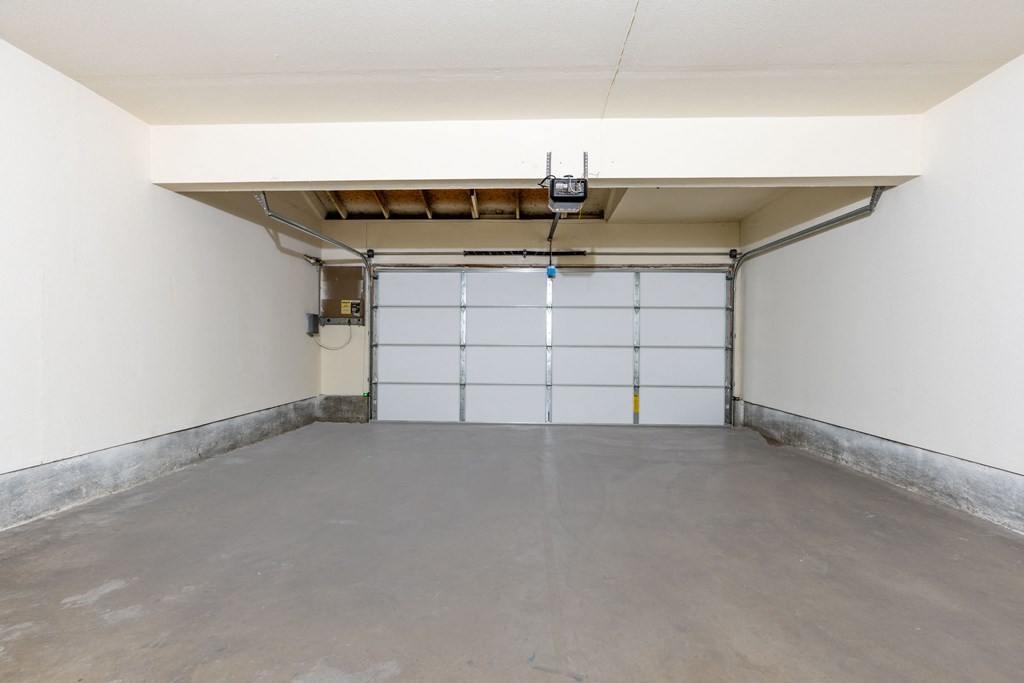 a empty garage with a white wall and a garage door