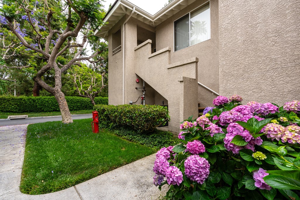 a house with flowers and a fire hydrant in front of it