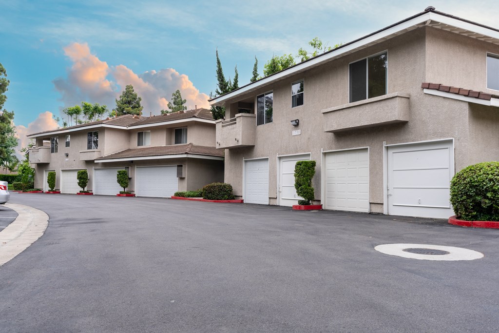 an empty street in front of a building with white garage doors