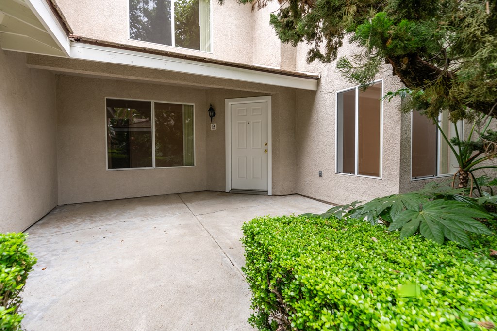the entrance to a building with a driveway and a white door