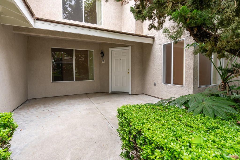 the entrance to a building with a driveway and a white door