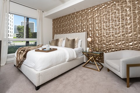 A bedroom with a large bed and a patterned wallpaper.