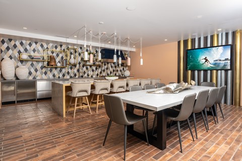 A modern dining room with a long table and chairs.