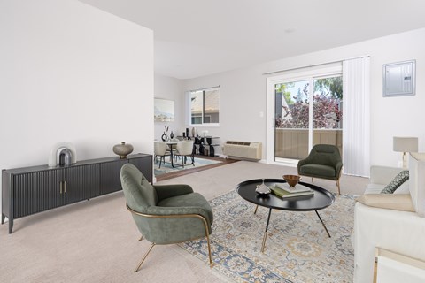 A living room with a green chair and a black cabinet.