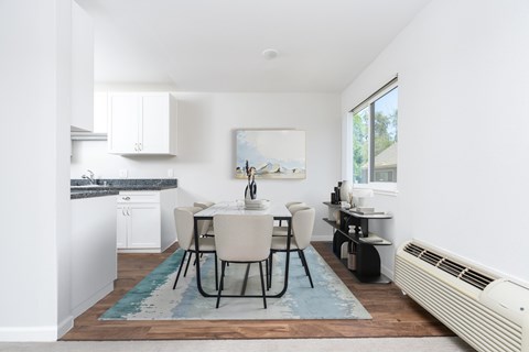 A kitchen with a table and chairs in the middle of the room.