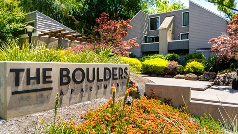 The Boulders Apartments is a modern apartment complex surrounded by a well-manicured garden.