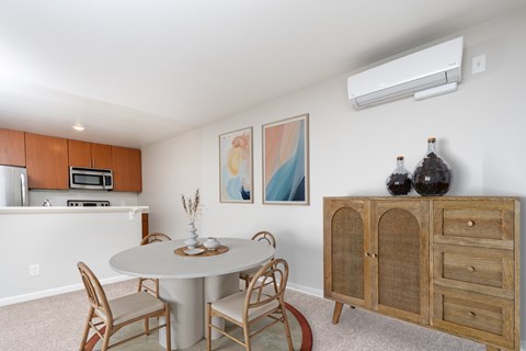 A dining room with a white table and chairs.
