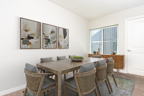A dining room with a wooden table and chairs.