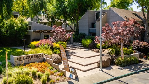 A sign that says "The Boulders" is in front of a building.
