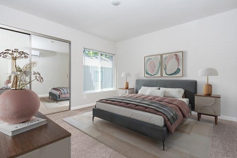 A bedroom with a large bed and a vase on a table.