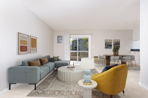 A living room with a grey couch, a yellow chair, and a white coffee table.