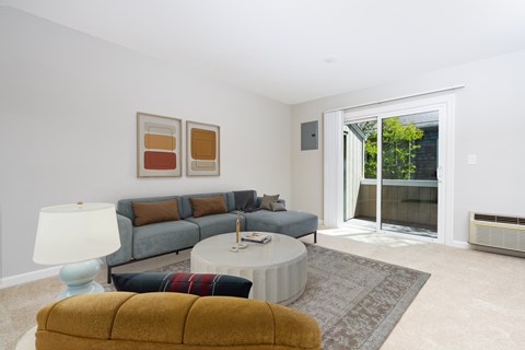 A living room with a grey couch, a yellow chair, a white table, and a lamp.