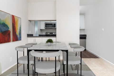 A modern dining room with a white table and chairs.