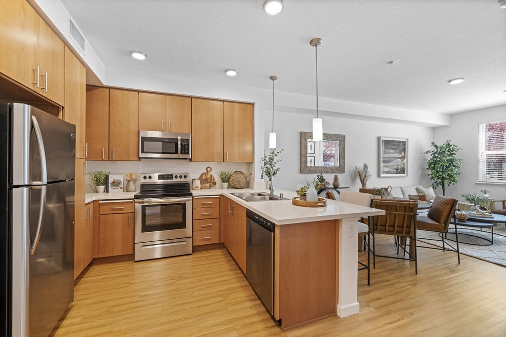 The Edge Milpitas CA a kitchen and living room with wood floors and white walls