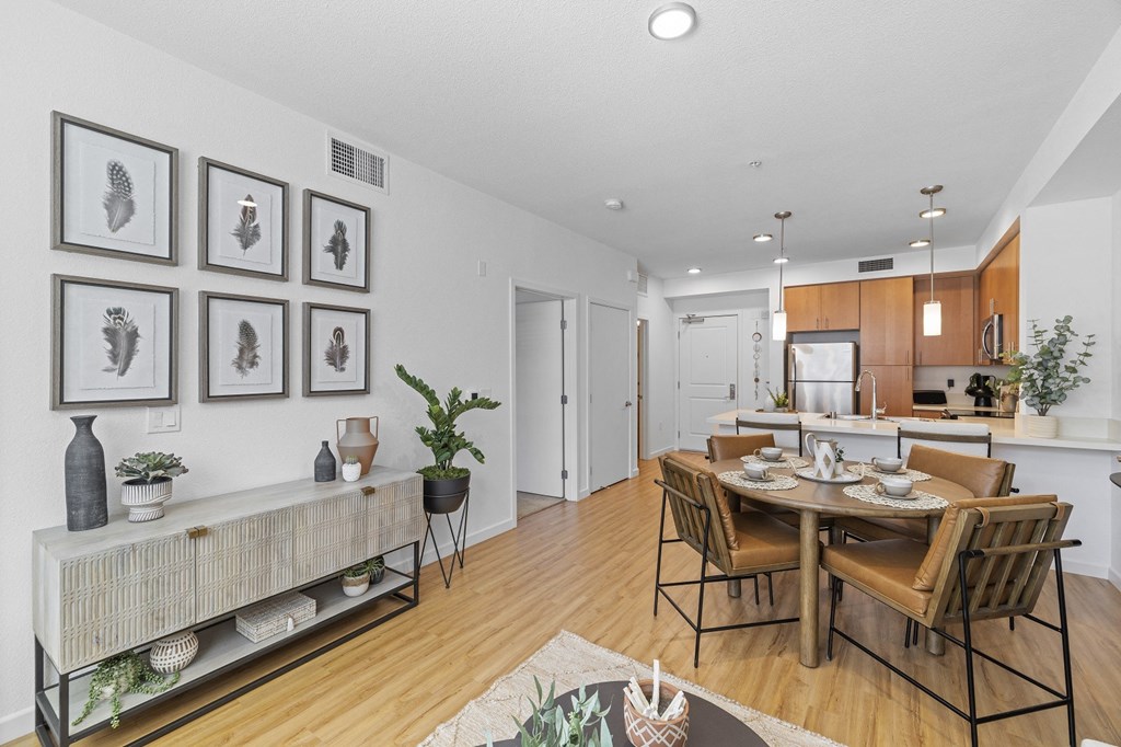 The Edge Milpitas CA a dining area with a table and chairs and a kitchen in the background