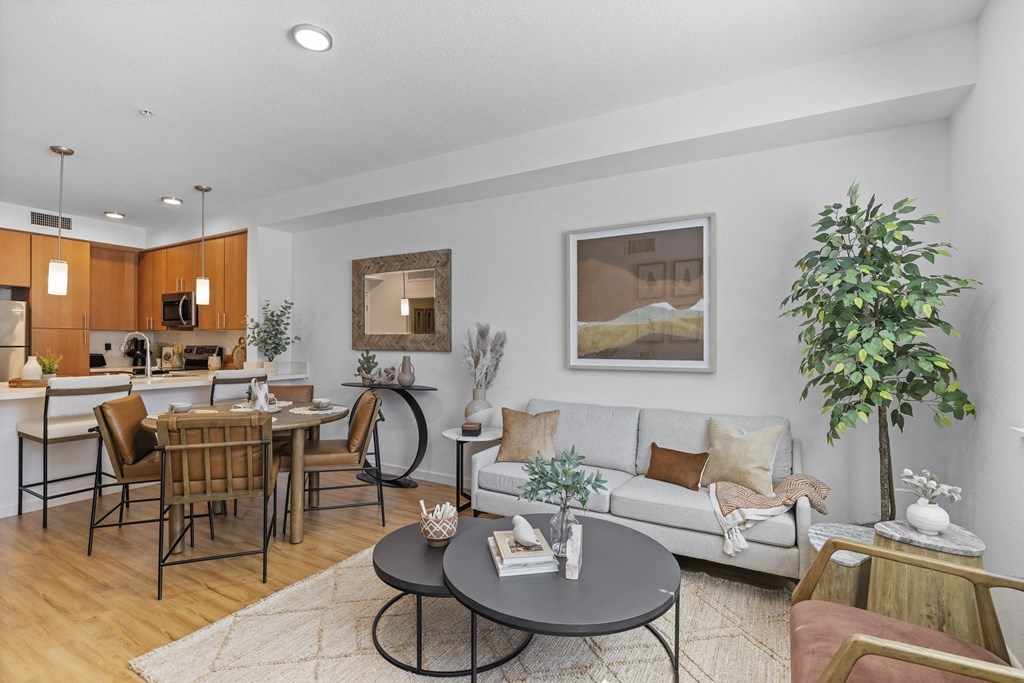 The Edge Milpitas CA a living and dining area with a couch table and chairs and a kitchen in the background